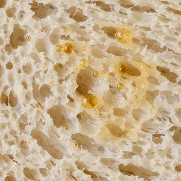 a microscopic view of bread's porous structure absorbing oil droplets effectively