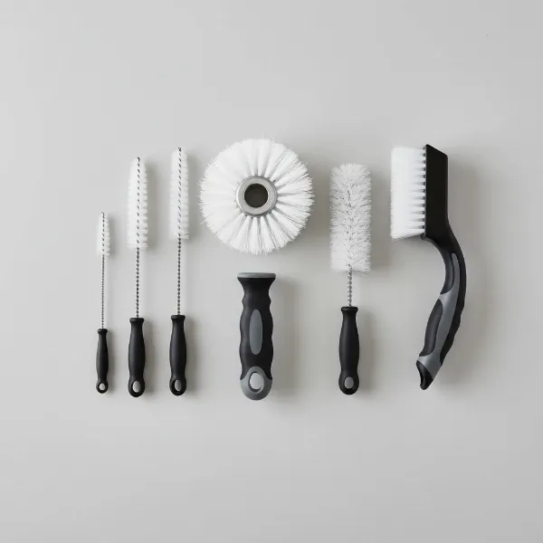 An assortment of specialized brushes for cleaning a meat grinder.